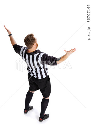 Back view. Full-length portrait of soccer or football referee wearing field judge uniform isolated on white studio background. Concept of sport, rules, competitions, rights, ad, sales. Back view. Full-length portrait of soccer or football referee wearing field judge uniform isolated on white studio background. Concept of sport, rules, competitions, rights, ad, sales. 86707146