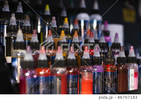 Palette of multicoloured tattoo inks. Tattoo salon. Selective focus, blurred. 86707183