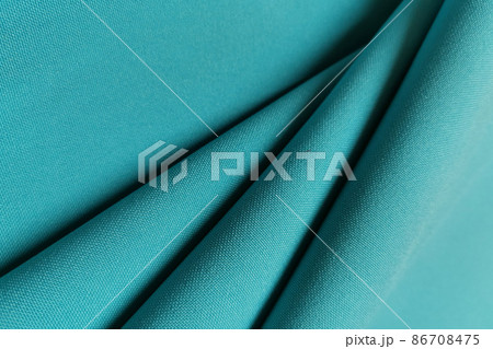 Green crumpled or wavy fabric texture background. Abstract linen cloth soft waves. Gabardine wool fabric. Merino yarn. Smooth elegant luxury cloth texture. Concept for banner or advertisement. 86708475