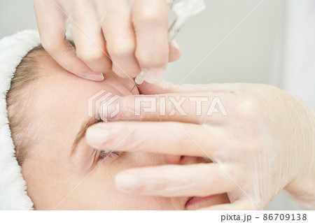 Injection at spa salon. Doctor hands in gloves. Closeup. Pretty female patient 86709138