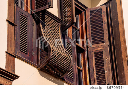 architectural elements of a historic house, beautiful windows with shutters, blinds and wooden bars 86709554