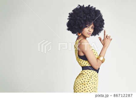 Bang bang. Studio shot of a young woman wearing a jumpsuit making a gun sign with her hands. 86712287