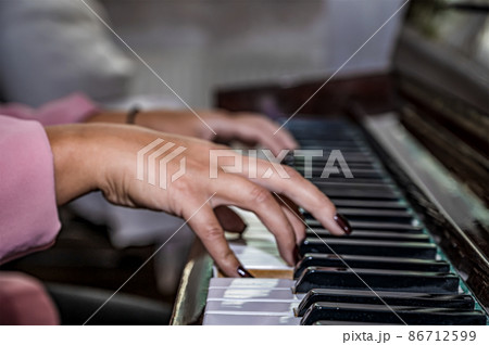 Close-up of female hands on the piano keyboard. playing piano while with both hands 86712599