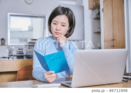 年金手帳を見つめて考える若い女性 86712896