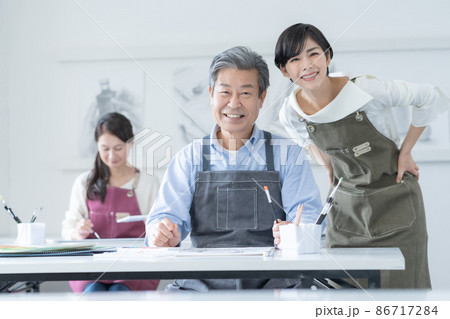 カルチャースクール　水彩画教室に通うシニア男性と女性と若い女性講師のポートレート 86717284