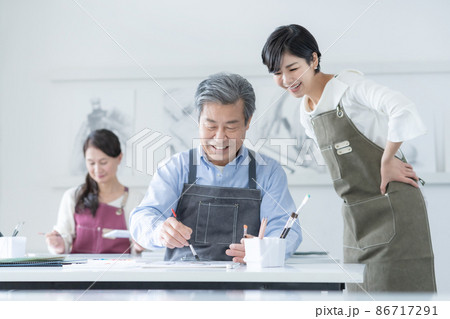 カルチャースクール　水彩画教室に通うシニア男性と女性　若い女性講師 86717291