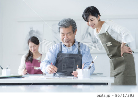 カルチャースクール　水彩画教室に通うシニア男性と女性　若い女性講師 86717292