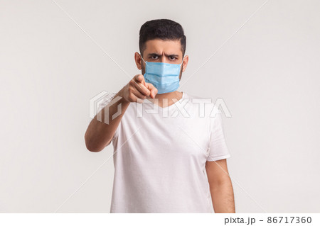 Hey you, use filters against novel influenza. Man pointing at camera and wearing hygienic mask to prevent coronavirus infection, respiratory diseases such as 2019-nCoV, ebola. studio shot, isolated Hey you, use filters against novel influenza. Man pointing at camera and wearing hygienic mask to prevent coronavirus infection, respiratory diseases such as 2019-nCoV, ebola. studio shot, isolated 86717360