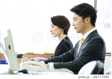 会社でデスクワークをする男女の会社員 会社でデスクワークをする男女の会社員 86717680