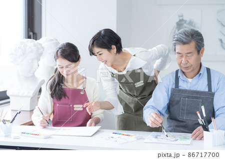 カルチャースクール 水彩画教室に通うシニア男性と女性 若い女性講師 カルチャースクール 水彩画教室に通うシニア男性と女性 若い女性講師 86717700