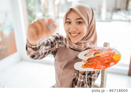 muslim female painter painting on canvas in her workshop 86718600