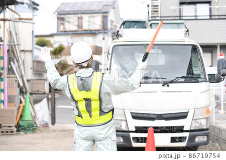 トラック（車両）を誘導する交通誘導員の男性 86719754