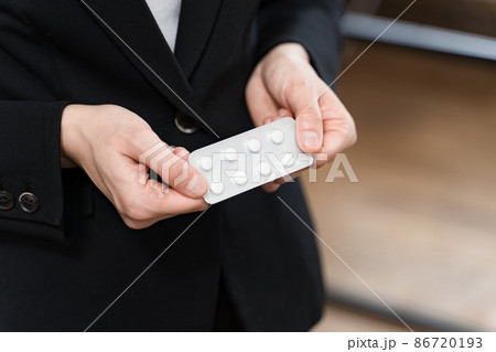 錠剤のPTP包装パッケージを手に持つスーツの女性　パーツカット 86720193