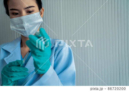 Skillful doctor prepare vaccine proficiently before injection Skillful doctor prepare vaccine proficiently before injection 86720200
