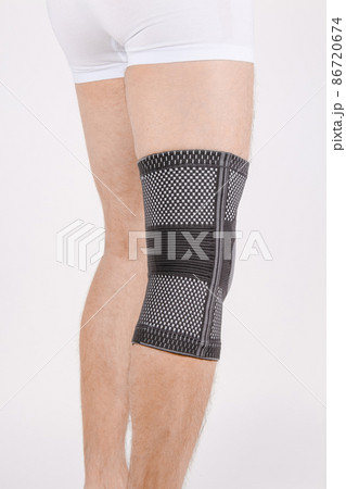 Knee Support Brace on leg isolated on white background. Elastic orthopedic orthosis. Anatomic braces for knee fixation, injuries and pain. Protective knee joint bandage sleeve. Trauma, rehabilitation. Knee Support Brace on leg isolated on white background. Elastic orthopedic orthosis. Anatomic braces for knee fixation, injuries and pain. Protective knee joint bandage sleeve. Trauma, rehabilitation. 86720674