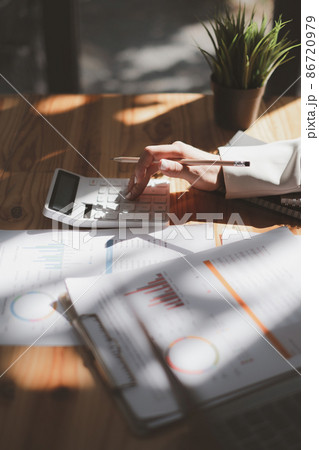 Close up Business woman using calculator for audit finance budget on wooden desk in office, tax, accounting, statistics and analytic research concept. Close up Business woman using calculator for audit finance budget on wooden desk in office, tax, accounting, statistics and analytic research concept. 86720979