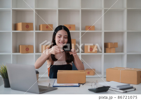Asian Business owner confirm address to send to customer orders talking by cell phone before pack products. Successful SME entrepreneur concept. 86721075