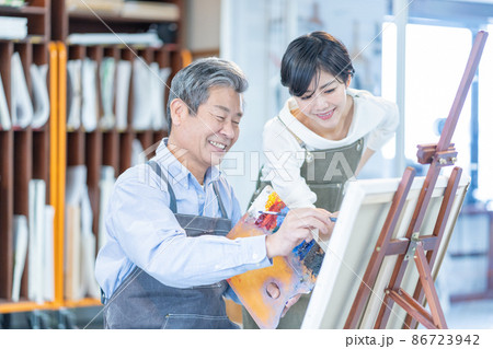 カルチャースクール　絵画教室に通うシニア男性と若い女性講師 86723942