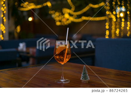 Aperol spritz summer cocktail in mister glass with lime, eco friendly straw and bubbles. Close up. High quality photo 86724265