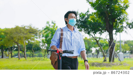 man walks with electric scooter 86724302