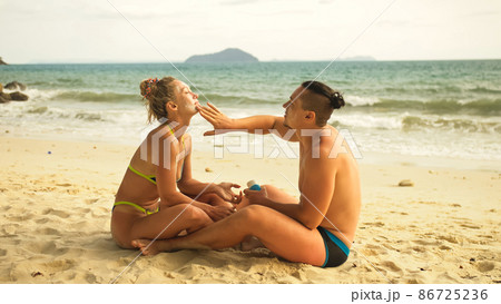 Cute loving couple each other having sun block. Woman to put sun Cute loving couple each other having sun block. Woman to put sun 86725236