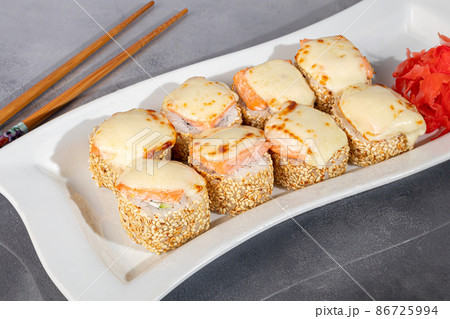 Sushi sets Uramaki, California, Philadelphia, rolls on a white plate. Menu for restaurants, cafes. On a dark reflective background. Sushi sets Uramaki, California, Philadelphia, rolls on a white plate. Menu for restaurants, cafes. On a dark reflective background. 86725994
