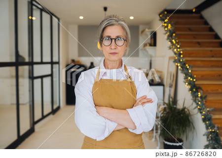 Portrait of strict granny standing in displeased pose staring angry at camera 86726820