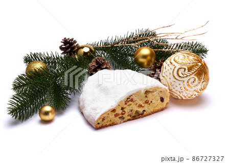 Sliced Traditional Christmas stollen cake with marzipan and dried fruit with New Year decorations 86727327
