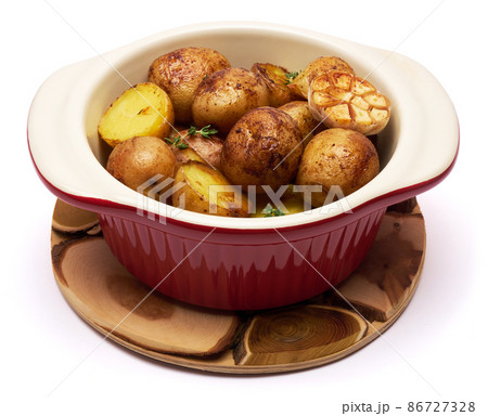Baked potato in a clay pot isolated on white background 86727328