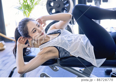 スポーツジムでトレーニングをする若い女性 86728770