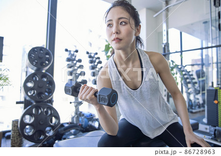 スポーツジムでトレーニングをする若い女性 86728963