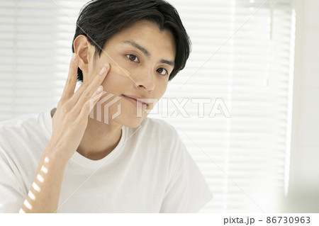 頬にBBクリームを塗る若い男性　メンズビューティ　メンズメイク　イメージ　ポートレート 86730963