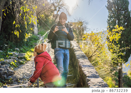 Dad and son travelers in Montenegro in Kotor Old Town Ladder of Kotor Fortress Hiking Trail. Aerial drone view 86732239