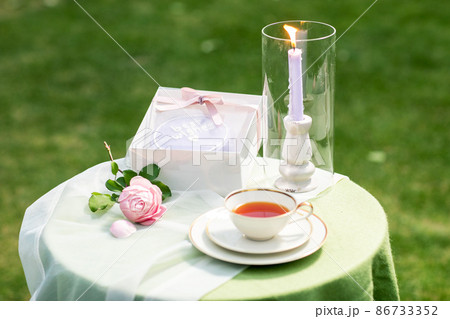 sweet cake with cup of tea and candle on table sweet cake with cup of tea and candle on table 86733352