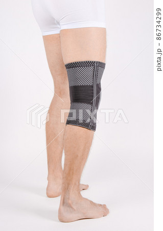 Knee Support Brace on leg isolated on white background. Elastic orthopedic orthosis. Anatomic braces for knee fixation, injuries and pain. Protective knee joint bandage sleeve. Trauma, rehabilitation. Knee Support Brace on leg isolated on white background. Elastic orthopedic orthosis. Anatomic braces for knee fixation, injuries and pain. Protective knee joint bandage sleeve. Trauma, rehabilitation. 86734299