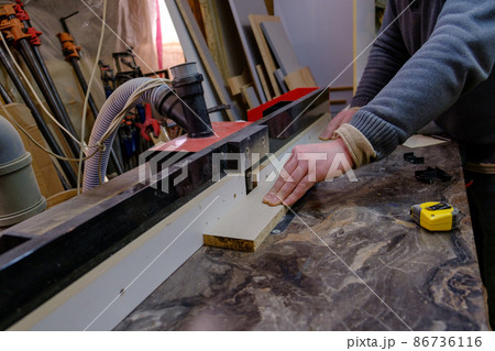 Mens hand sawing wood on circular saw, machine which saws wood, particle Board and fiberboard, production of furniture, selective focus 86736116