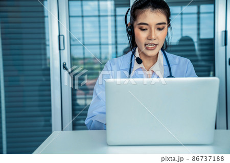 Doctor wearing headset talking actively on video call in hospital or clinic 86737188