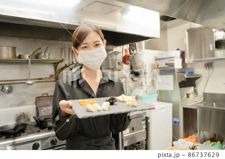 感染症対策のマスクをして食事提供する女性スタッフ 感染症対策のマスクをして食事提供する女性スタッフ 86737629