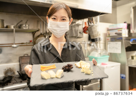 感染症対策のマスクをして食事提供する女性スタッフ 86737634