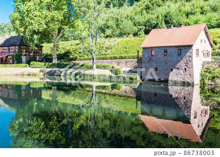 Reflecting historical buildings in calm water 86738003