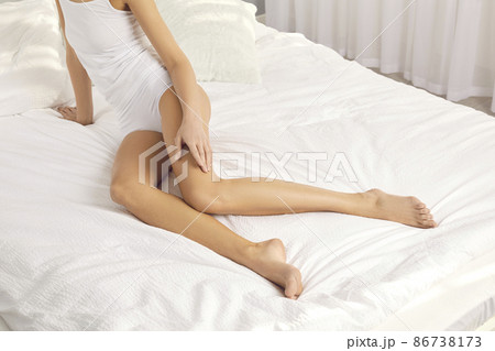 Slim woman posing in underwear in light modern bedroom interior. Young barefoot European model in cotton panties, with long, thin, smooth, shaved or waxed hairless legs sitting on soft clean fresh bed Slim woman posing in underwear in light modern bedroom interior. Young barefoot European model in cotton panties, with long, thin, smooth, shaved or waxed hairless legs sitting on soft clean fresh bed 86738173