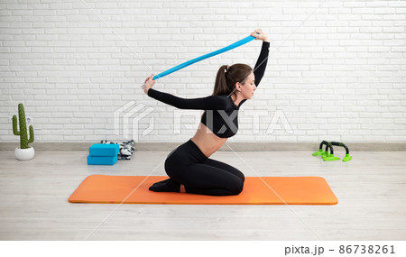 the girl conducts a home workout stretching to strengthen her back the girl conducts a home workout stretching to strengthen her back 86738261