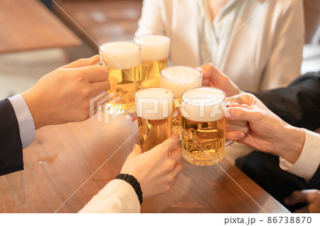 ビールで乾杯する会社帰りの打ち上げ飲み会手元 86738870