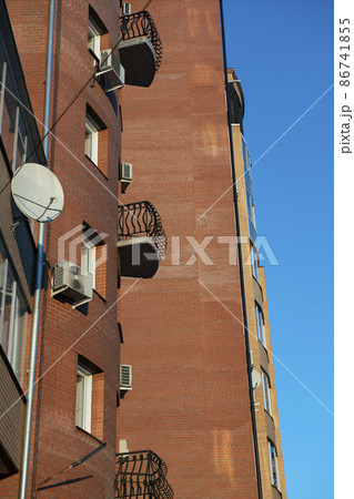 A small open balcony on the facade of a brick building. A small open balcony on the facade of a brick building. 86741855