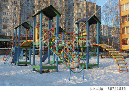 Children's playground in the courtyard in winter on a sunny day. Children's playground in the courtyard in winter on a sunny day. 86741856