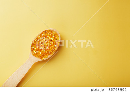 Vitamin D3 Capsules in a spoon with other vitamin D3 capsules around them on a yellow background Vitamin D3 Capsules in a spoon with other vitamin D3 capsules around them on a yellow background 86743992