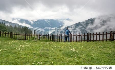 Man watching the Black Sea region mountains with clouds and dramatic skies. Green nature landscape of trees and forests in rural highlands of Black Sea Karadeniz region, Turkey 86744536