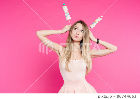 Funny girl holding marshmallows on stick under 86744663