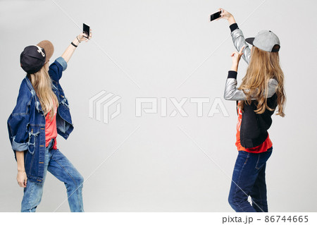 Two girls in stylish clothing taking selfie on 86744665