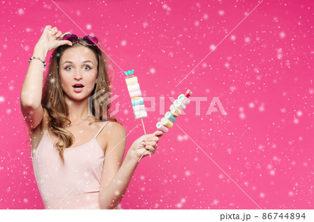 Funny girl holding marshmallows on stick under Funny girl holding marshmallows on stick under 86744894